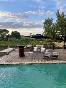 - une terrasse avec des chaises et un parasol à côté de la piscine dans l'établissement La Belugue, à Beaumont-de-Pertuis