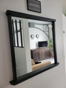 un espejo colgado en una pared en una sala de estar en Breuil Station, studio tout confort, en La Mure