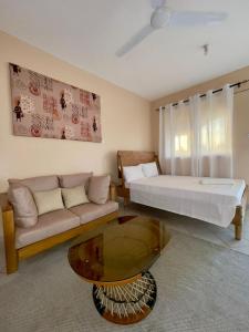 ein Wohnzimmer mit einem Bett, einem Sofa und einem Tisch in der Unterkunft Dasha Studio apartment Bamburi D4 in Bamburi