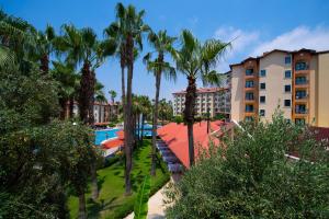 - une vue sur un complexe avec une piscine et des palmiers dans l'établissement Miramare Queen Hotel, à Sidé