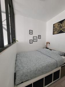 1 dormitorio con 1 cama en una pared blanca en Breuil Station, studio tout confort, en La Mure