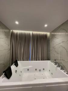 uma grande banheira branca na casa de banho em Reign Hotel em Vorë