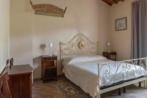 een slaapkamer met een wit bed en een houten tafel bij Agriturismo Le Pozze in Poppi