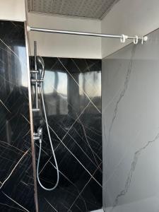 a shower in a bathroom with a black marble wall at Gemütliches Zimmer in guter Lage in Addis Ababa