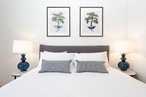 1 dormitorio con 1 cama blanca y 2 lámparas en Bellevue Beauty, en Sídney