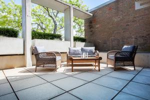 drie stoelen en een bank op een patio bij Bellevue Beauty in Sydney