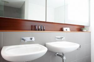 La salle de bains est pourvue d'un lavabo blanc et d'un miroir. dans l'établissement Bellevue Beauty, à Sydney