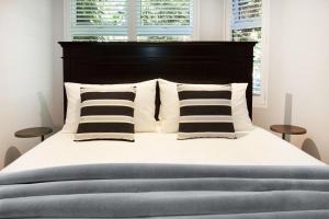 - un lit avec une tête de lit et des oreillers en noir et blanc dans l'établissement Bayside Retreat, à Sydney