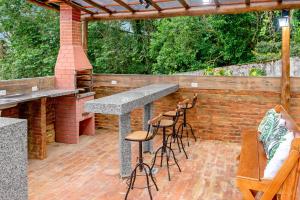 a patio with a bar and stools at Paradisiacal getaway -Serra Negra in Serra Negra