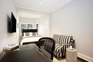 a living room with a bed and a chair at Bayside Retreat in Sydney