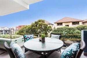 patio con mesa y sillas en el balcón en Blissful Bream en Sídney