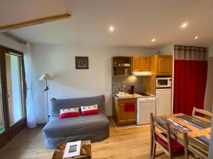 ein Wohnzimmer mit einem Sofa und einer Küche in der Unterkunft AU COEUR DU GOLF **, Giez, proche Lac d' Annecy in Giez