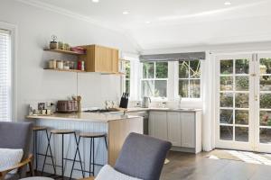 朗塞斯顿Bluestone Cottage Launceston的带柜台、椅子和窗户的厨房