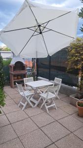 a table and chairs with an umbrella and a grill at LA CASA DI PICCOLI' di Gabriele Martelli e Catia Pacetti - Camera APE in Ancona