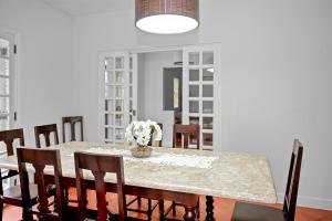 a dining room table with chairs and a vase of flowers at Paradisiacal getaway -Serra Negra in Serra Negra +20 photos