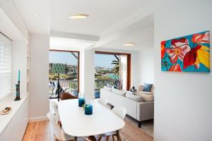 a living room with a white table and chairs at Barefoot in Bronte IH in Sydney
