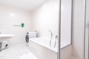 ein weißes Bad mit einer Badewanne und einem WC in der Unterkunft 4k TV, Soundbar, Ausblick in Bad Dürrenberg