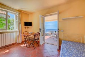 a room with a bed and a table and a balcony at Mare e natura in Marciana
