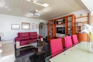 uma sala de estar com cadeiras cor-de-rosa e uma mesa de vidro em Torremolinos Playamar Primera Linea de Playa Urb. La Farola em Torremolinos