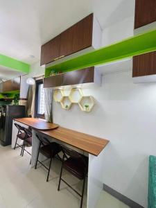a kitchen with a table and some green accents at Studio 7 in Manila
