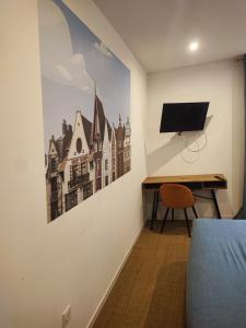 a bedroom with a desk and a tv on a wall at APPART'HOTEL EDEN in Béthune