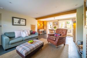 a living room with a couch and a chair at Goose Cottage by Big Skies Cottages in Titchwell