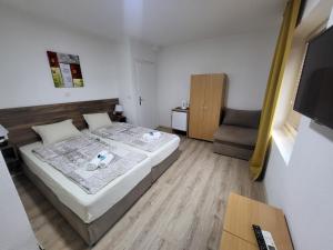 um pequeno quarto com uma cama e uma cadeira em Villa Pegasus Pestani em Ohrid