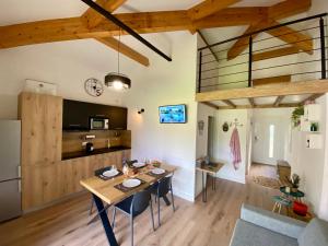 a dining room and living room with a table and chairs at Appart Cala Rossa - T2 Porto-Vecchio in Lecci
