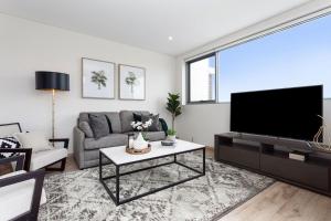 sala de estar con TV y sofá en Bream Penthouse en Sídney