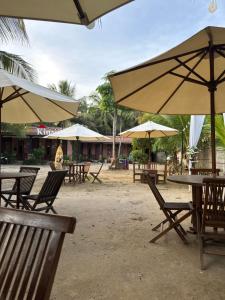 a group of tables and chairs with umbrellas at Kinasih Homestay in Pacitan