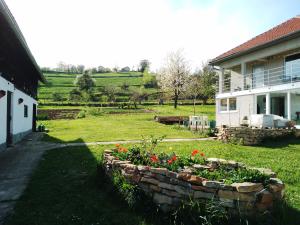 a garden in front of a house with flowers at Apartment Pirol: Dorf Hideaway Gornja Breza in Breza