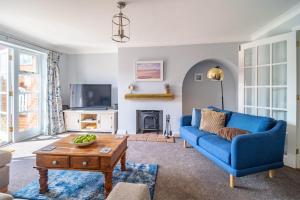 a living room with a blue couch and a table at Birch Cottage in Northrepps