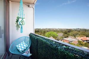 a balcony with a blue chair and a view at Centennial Retreat in Sydney