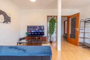 a living room with a blue couch and a tv at 4k TV, Soundbar, Ausblick in Bad Dürrenberg
