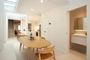 a kitchen and dining room with a wooden table and chairs at Wharf House Woolloomooloo in Sydney