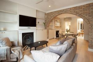 a living room with a couch and a fireplace at Wharf House Woolloomooloo in Sydney