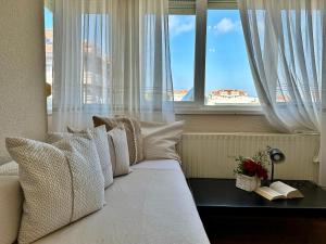 a bedroom with a white bed with a window at El Nido de Ris in Noja