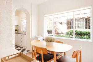a kitchen and dining room with a table and a window at Coastal Calm Coogee in Sydney