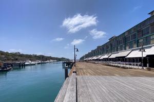 a wooden dock with a building next to the water at Wharf House Woolloomooloo in Sydney