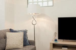um candeeiro de chão ao lado de um sofá e uma televisão em Charming Bream em Sydney