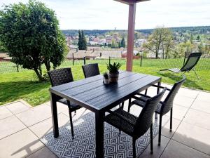 a wooden table and chairs on a patio at Modernes Panorama-Domizil in Schömberg