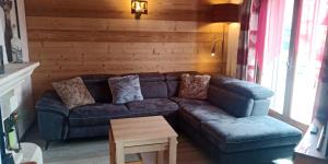 Una sala de estar con un sofá de cuero y una mesa. en La Fugue en Bresse, en La Bresse 3 fotos más