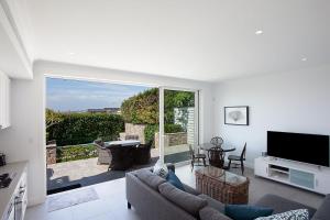 a living room with a couch and a television at Villa Bianca Clovelly in Sydney