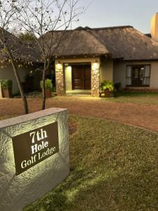 a sign in front of a house with a golf house at 7th Hole Golf Lodge in Modimolle