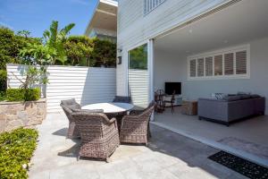 patio z krzesłami, stołem i kanapą w obiekcie Villa Bianca Clovelly w mieście Sydney