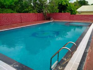 a large blue swimming pool with a metal hand rail at Vacation Village Camps - A Unit Of Braham Vatika Resort in Pushkar +37 photos
