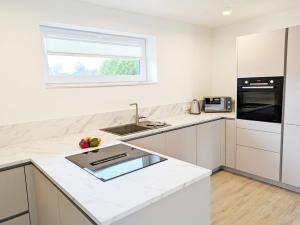 a white kitchen with a sink and a window at Ferienwohnung Emilia in Garding