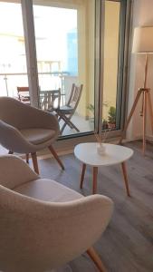 een kamer met stoelen, een tafel en een balkon bij Sesimbra Cliffs OceanView - 5min walk to Beach in Sesimbra