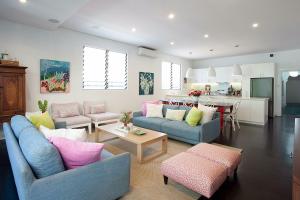 sala de estar con 2 sofás azules y cocina en Colourful Coogee en Sídney