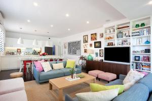 sala de estar con 2 sofás azules y cocina en Colourful Coogee en Sídney